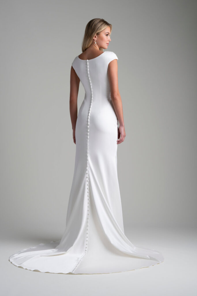 A beautifully draped cowl neck is the showpiece of this understated bridal sheath.
